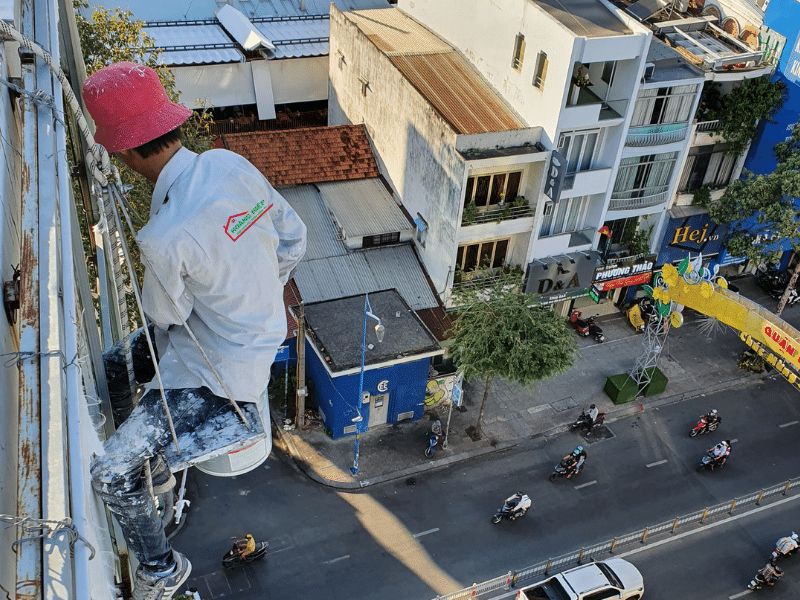 Thợ sơn Hoàng Hiệp đang sơn tòa nhà